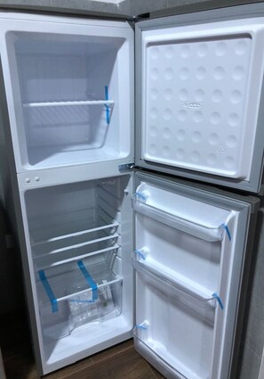 A white refrigerator with two door shelves and a freezer compartment. - Spacious 3-bedroom and 2 bathroom home with private pool and patio and free Wi-Fi (Calango)
