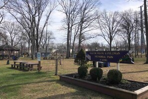 Un parc avec une plaque commémorative en hommage au maire Frank G. Pelzman, des tables de pique-nique et des arbres sans feuilles.