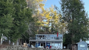 Un edificio de dos pisos con base de piedra, un balcón y un cartel que dice "Welcome to the Lake".