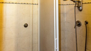 Un baño con inodoro, cabina de ducha y lavabo.