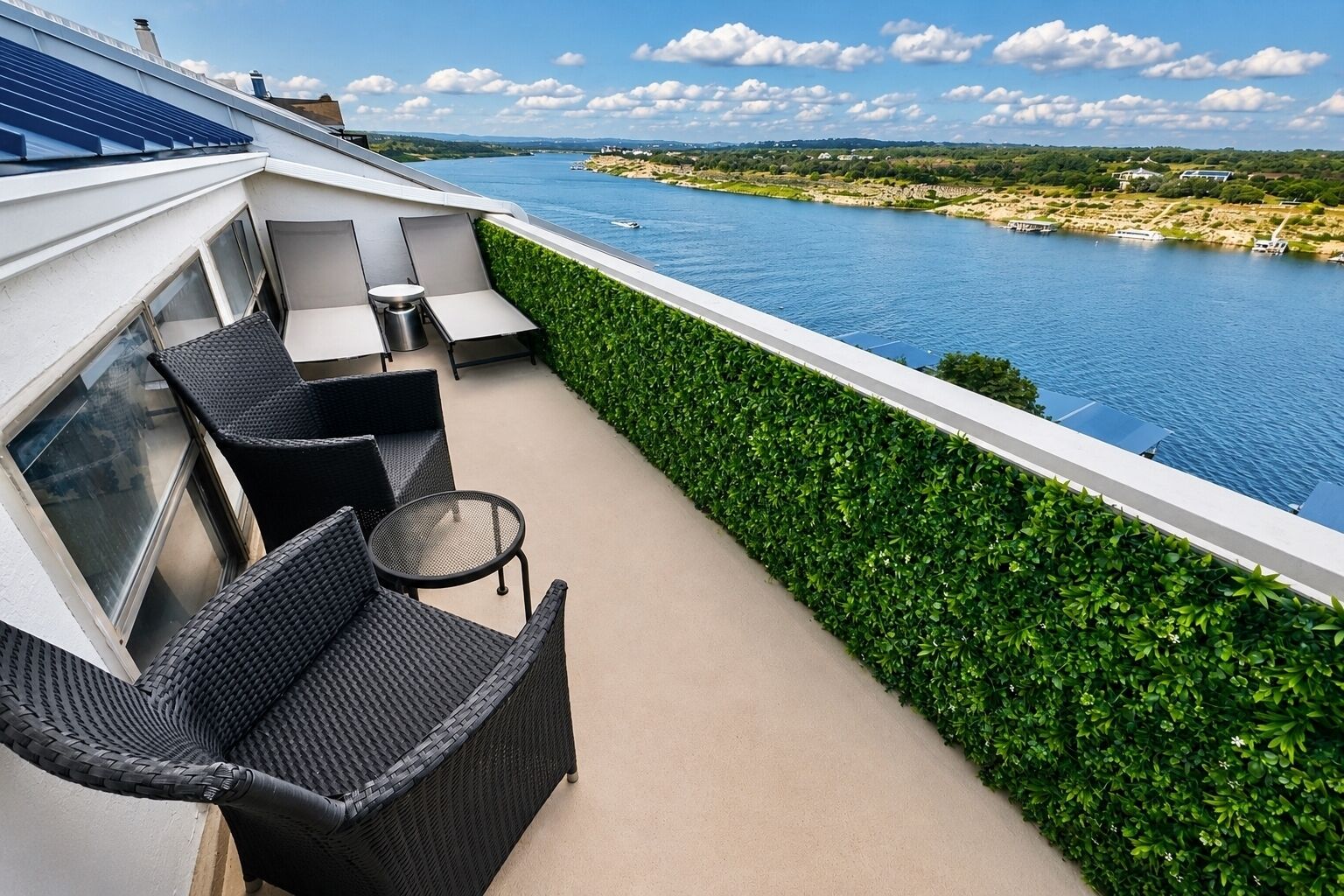 A balcony with a view of a river, outdoor furniture, and solar panels.