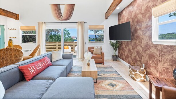 A modern living room with a sofa, a coffee table, and a TV mounted on the wall.