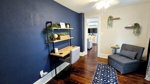 Una sala de estar moderna con una pared azul de acento, un sofá gris, una mesa de centro de madera y una alfombra estampada.