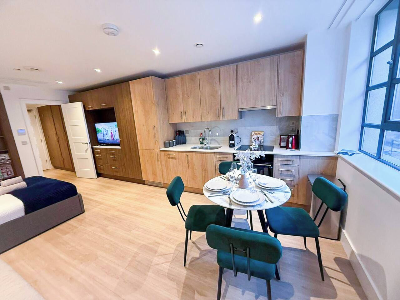 A modern apartment with a dining area, kitchen, and a living room.