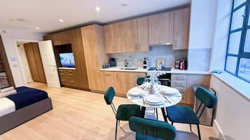 A modern apartment with a dining area, kitchen, and a living room.