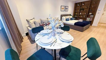 A dining area with a round table set for four, surrounded by four chairs.