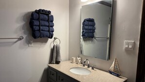A bathroom with a sink, mirror, towel rack, and a small ship decoration. - The Getaway @ Nolin  (Clarkson)