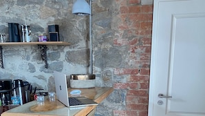 A compact kitchen with a wooden countertop, a laptop, a coffee maker, and a hanging light fixture. - HexenburgbeiDresden Stylishes Designerappartement mit Schlafsofa, Terrasse - Nähe Sächsische Schweiz (Grossharthau)