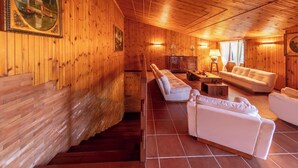 A wooden interior with a staircase, white sofas, and a dining area. - Villangelo - Camera Matrimoniale (Aiello del Sabato)