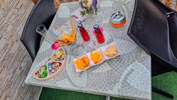 A table with snacks, drinks, and a decorative vase.
