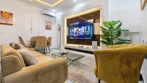 Un salon moderne doté d’un téléviseur à écran plat, de sièges confortables et d’un coin repas.