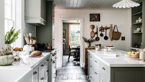A kitchen with white cabinetry, a central island, and a view into the dining area.