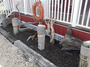 A wooden deck with a white railing, a lifebuoy, and decorative posts.