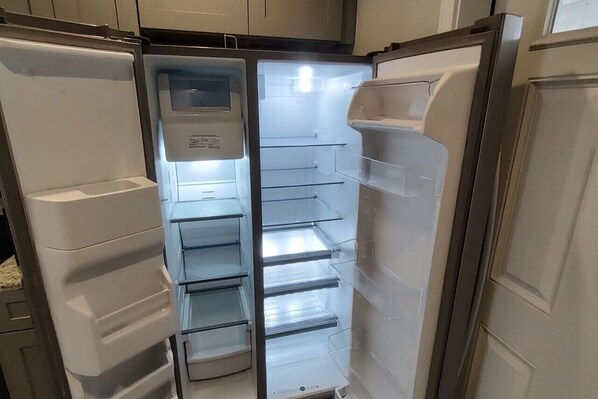 A kitchen with a refrigerator, a microwave, and a sink.