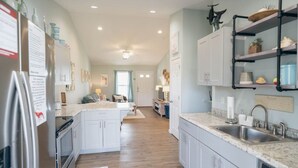A modern kitchen with white cabinets, a granite countertop, and a built-in sink.