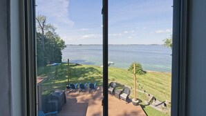 A deck with outdoor seating and a view of a lake.