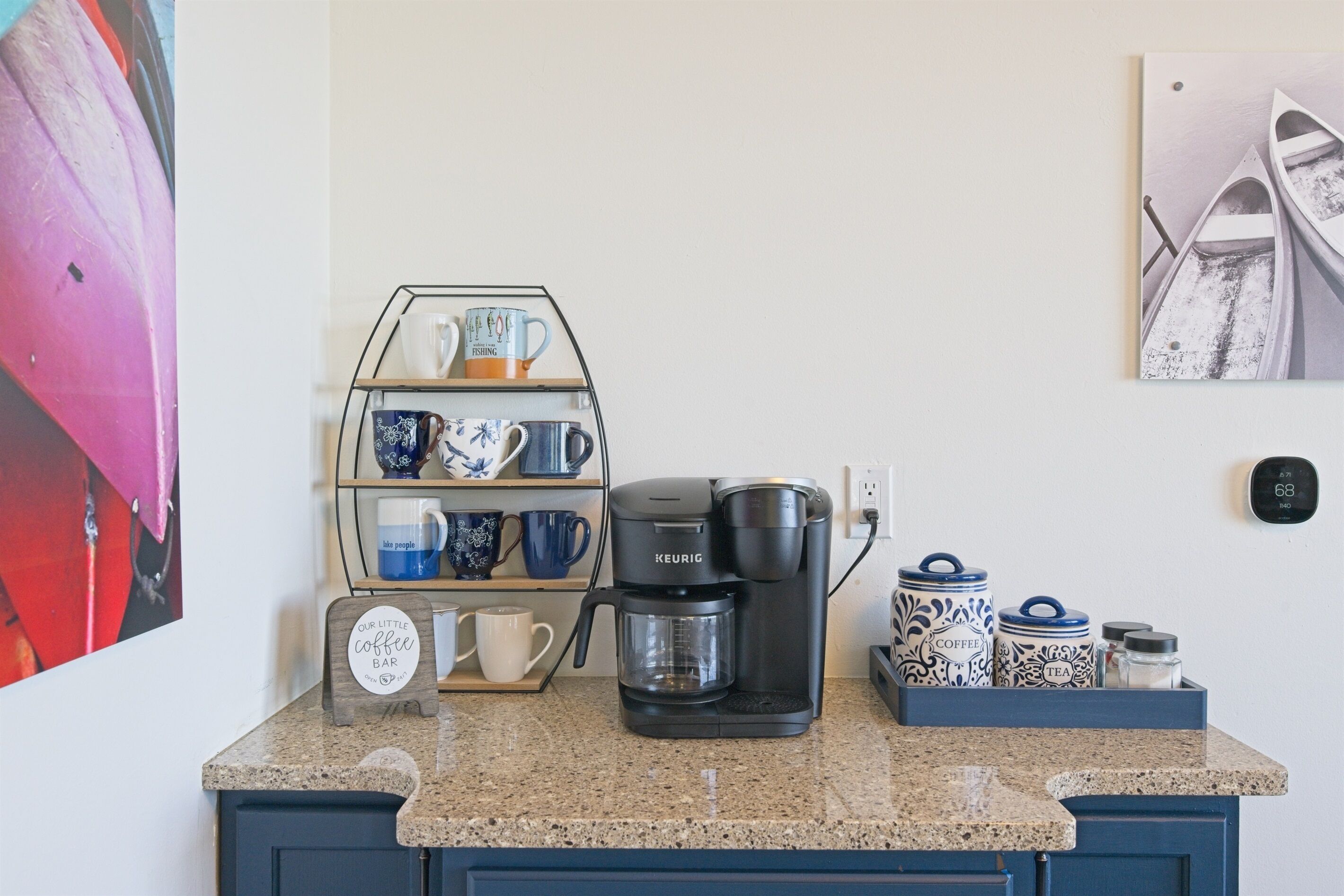 A kitchen counter with a Keurig coffee maker, a mug rack, and coffee containers.