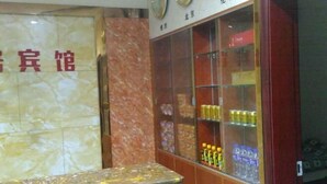 A reception desk with a marble wall and a glass display case containing various items. - Dongzhi IKEA Business Hotel (Dongzhi)