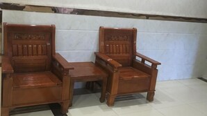 Two wooden chairs and a small table in a room with white tiled walls and a tiled floor. - Dongzhi IKEA Business Hotel (Dongzhi)