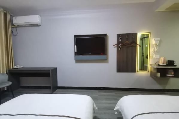 A hotel room with two beds, a desk, a TV, a mirror, and a wardrobe. - Dongzhi IKEA Business Hotel (Dongzhi)