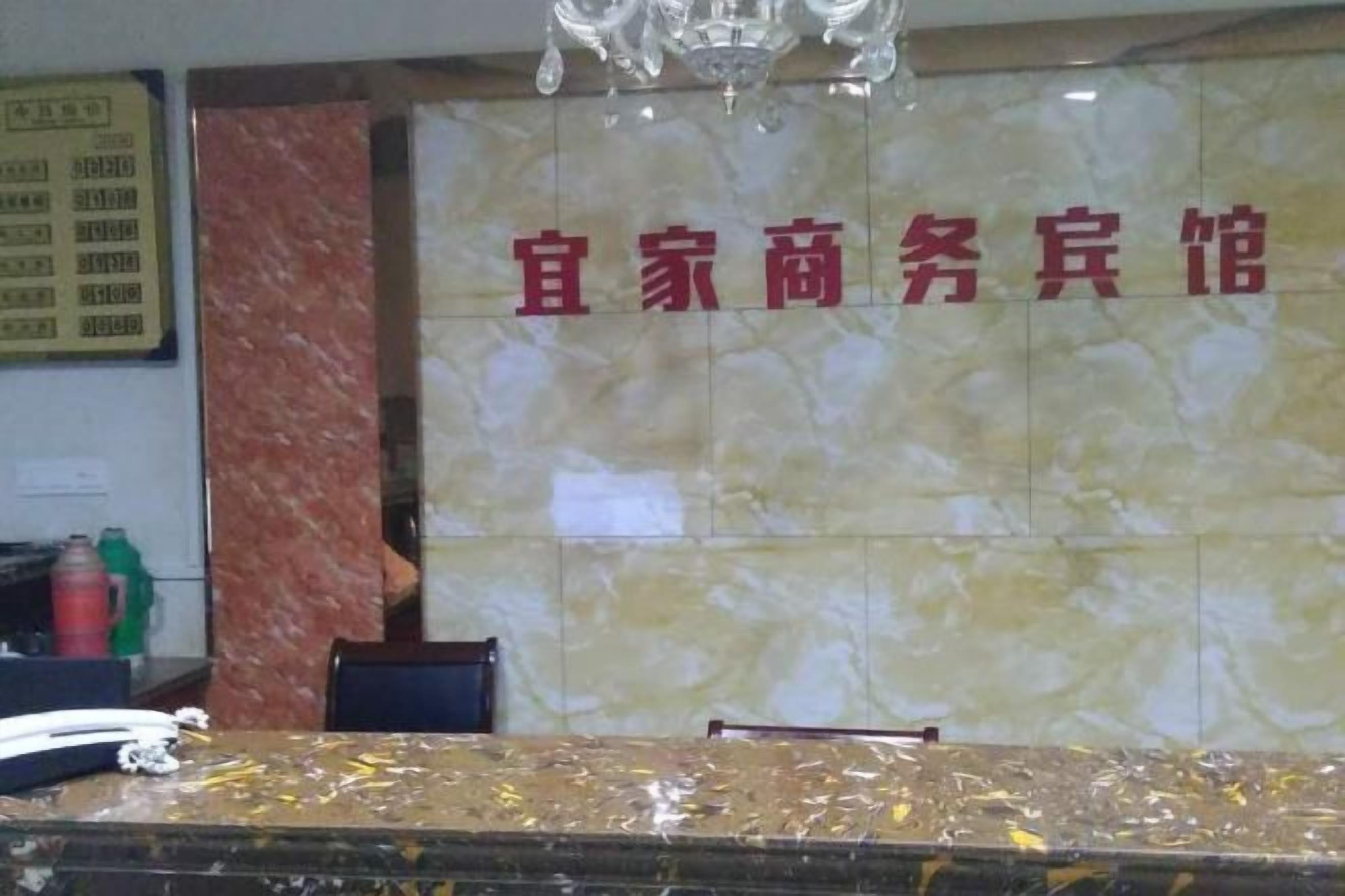 Un área de recepción con pared de mármol y mostrador de recepción.