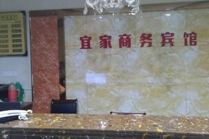 A reception area with a marble wall and a reception desk.