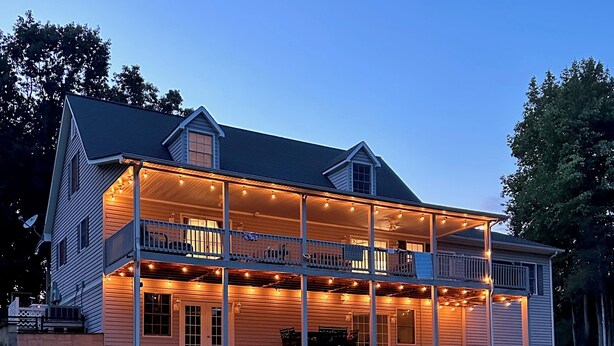 A two-story house with a porch and a garage. - Serene waterfront home at Smith Mountain Lake in Huddleston, VA (Huddleston)