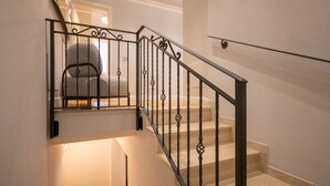 Una escalera con barandilla metálica y un rellano alfombrado.