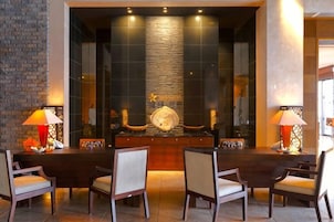 Un comedor con una mesa larga, sillas y un centro de mesa decorativo.