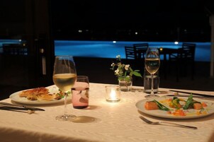 Una mesa puesta para cenar con platos de comida, copas de vino y una vela.