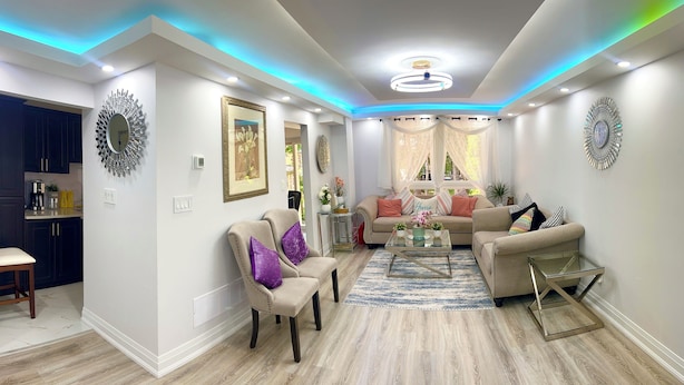 A modern living room with a sofa, chairs, a coffee table, and decorative items. - Super Luxury House with 3 Bedrooms, 1-1/2 Washrooms, Basement and Free Parking (Toronto)