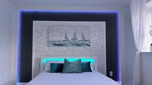 A bedroom with a marble headboard, a painting of sailboats, and a bed with teal pillows. - Super Luxury House with 3 Bedrooms, 1-1/2 Washrooms, Basement and Free Parking (Toronto)