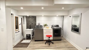 A compact kitchen with a sink, countertop, and a small island with a red stool. There is a mirror on the wall and a door leading to another room. - Super Luxury House with 3 Bedrooms, 1-1/2 Washrooms, Basement and Free Parking (Toronto)