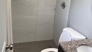 Ein Badezimmer mit Dusche, Toilette und Waschbecken.