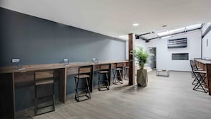 Eine moderne Bar mit Holztresen und Metallstühlen.