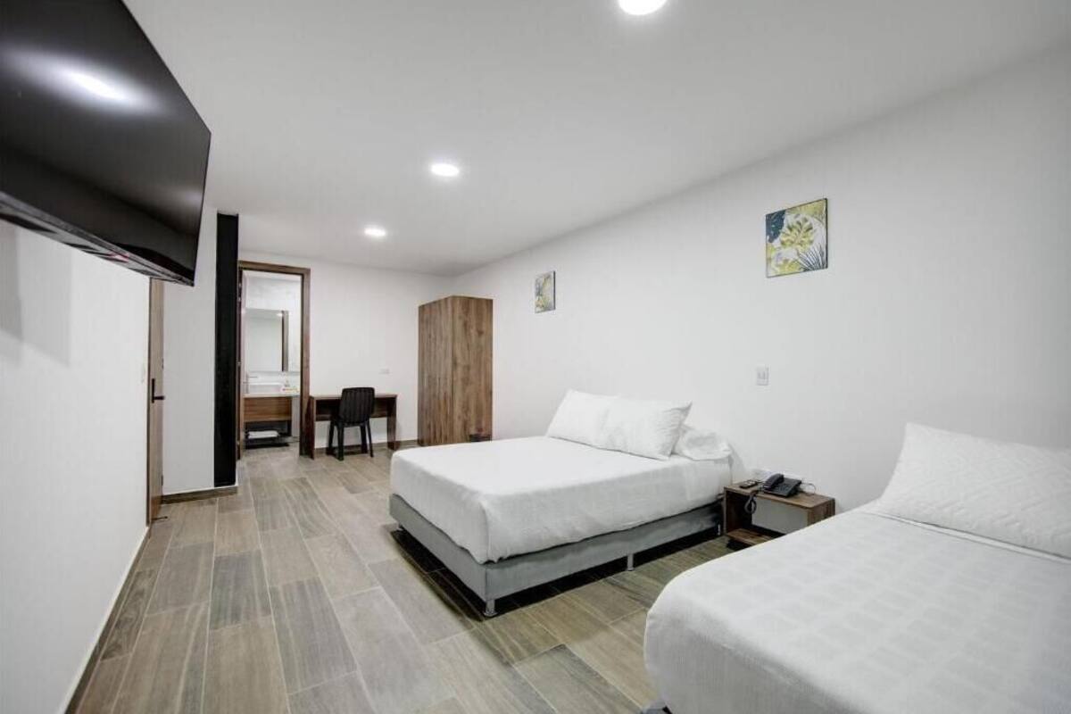 Una habitación de hotel con dos camas, un escritorio y una silla.