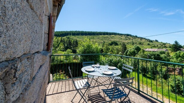 A balcony with a table and chairs, overlooking a green landscape and hills. - 2-person rental in Les Badieux (BONDONS (LES))