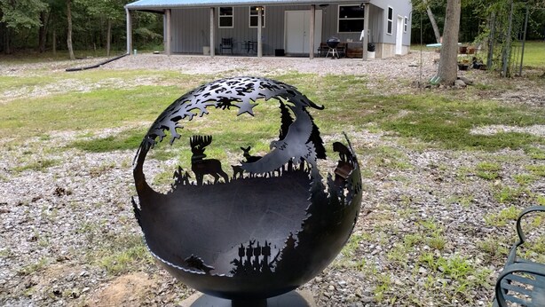 Una escultura de metal con siluetas de animales en un jardín.