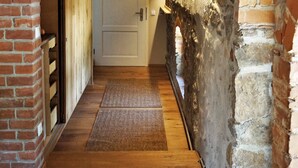 A narrow hallway with wooden flooring, a brick wall on the left, and a stone archway on the right. - HexenburgbeiDresden 2 Zimmer Architektenwohnung mit eigener Sauna, Whirlwanne und Kamin - Nähe Sächsische Schweiz (Grossharthau)