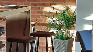 A brick wall, a potted plant, and a bar stool. - HexenburgbeiDresden 2 Zimmer Architektenwohnung mit eigener Sauna, Whirlwanne und Kamin - Nähe Sächsische Schweiz (Grossharthau)