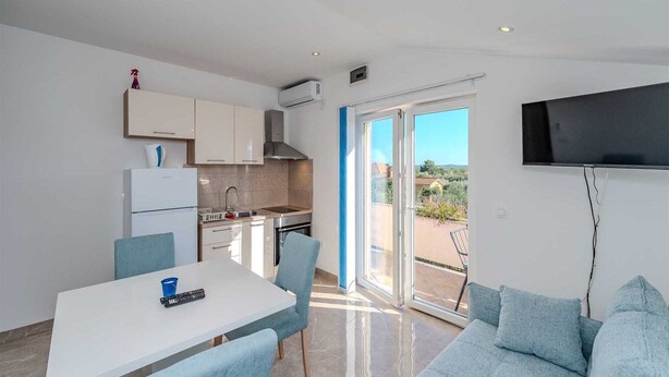 A modern kitchen with a dining area and a balcony. - Emila's Apartment- Blue (Nin)
