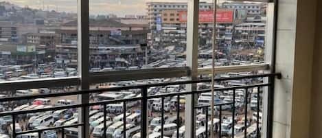 A room with a large window overlooking a busy parking lot and a cityscape.