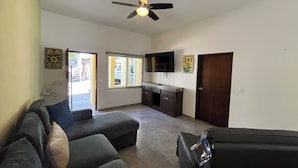 A living room with a sofa, a television, and a ceiling fan. - Casa Sueños in Bucerias Mexico with Private Pool and Private Parking Garage.  (Bucerías)