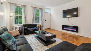 A modern living room with a black sofa, a coffee table, and a fireplace.