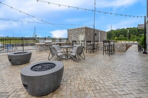 Un espacio de patio al aire libre con paredes de piedra, una parrilla y zonas de estar.