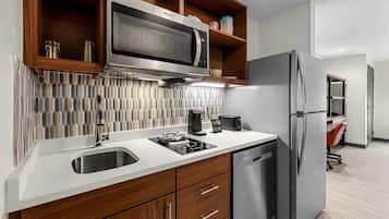 A modern kitchen with a built-in microwave, stainless steel appliances, and wooden cabinetry.
