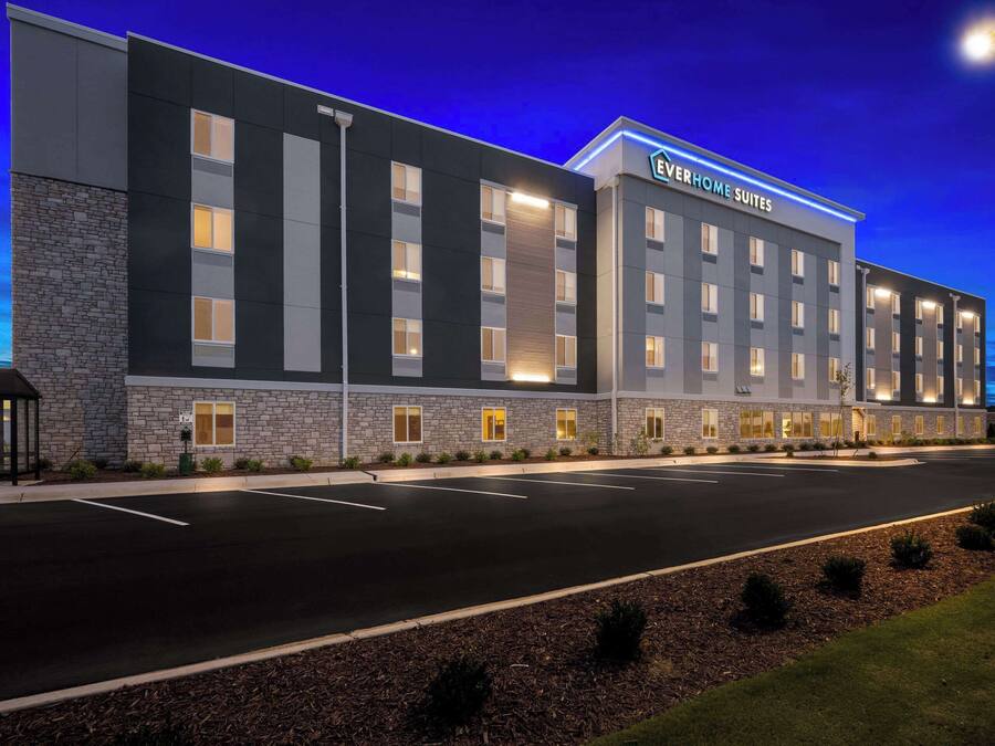 A hotel with a modern exterior, multiple floors, and a well-lit facade.