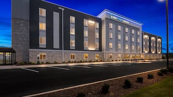 Um hotel moderno com telhado plano, várias janelas e uma placa com a inscrição 'EverHome Suites'.