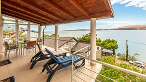 A covered outdoor area with a view of a lake and distant mountains.