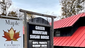 A sign for Green Mountain Sugar House with a maple leaf logo and mentions maple products, Vermont cheese, candy kitchen, and gifts. - Four Season Ski, Lake & Golf Chalet on Beautiful Lake Rescue in Ludlow (Ludlow)